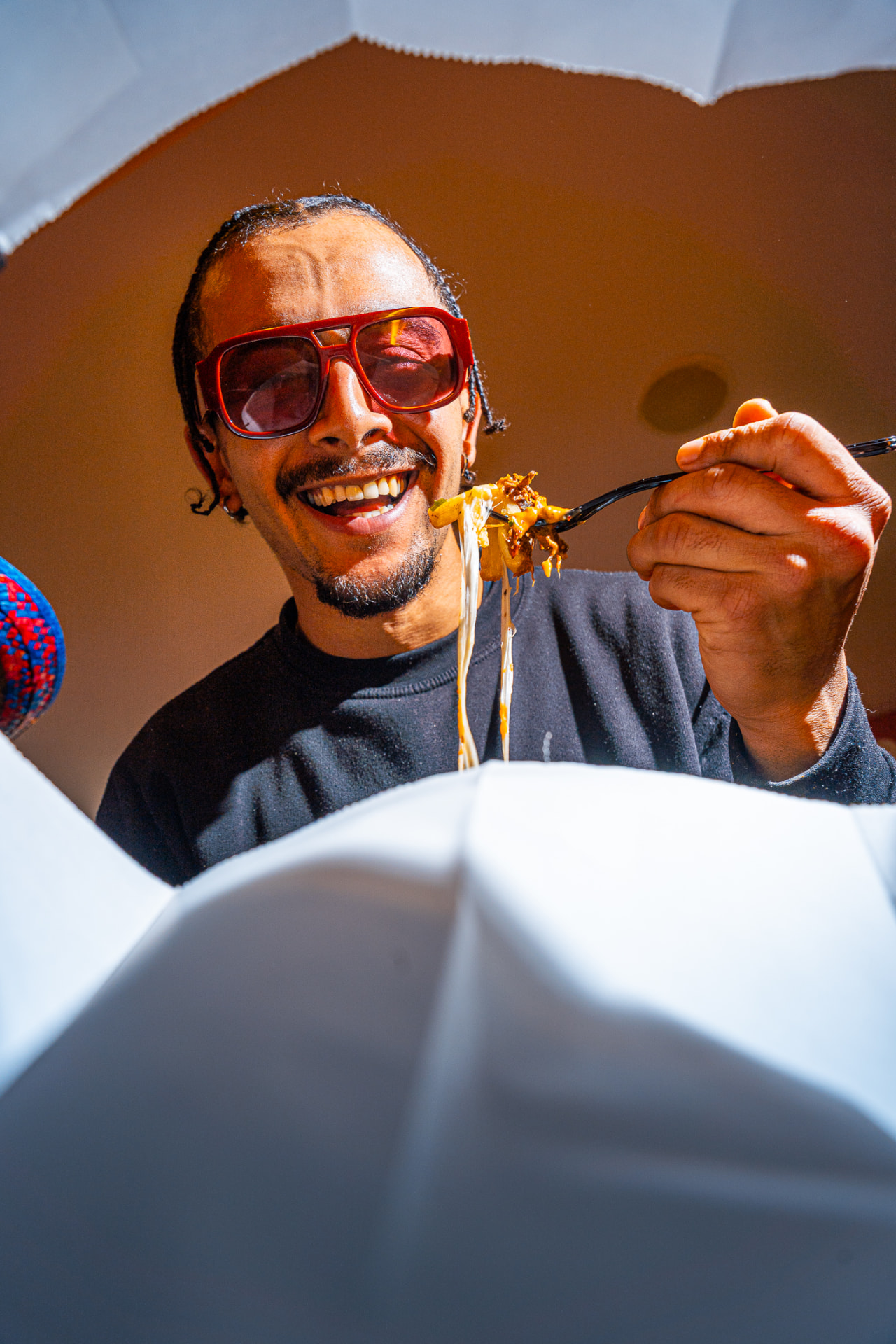 Customer eating cheesy loaded fries from a takeaway box, Leeds