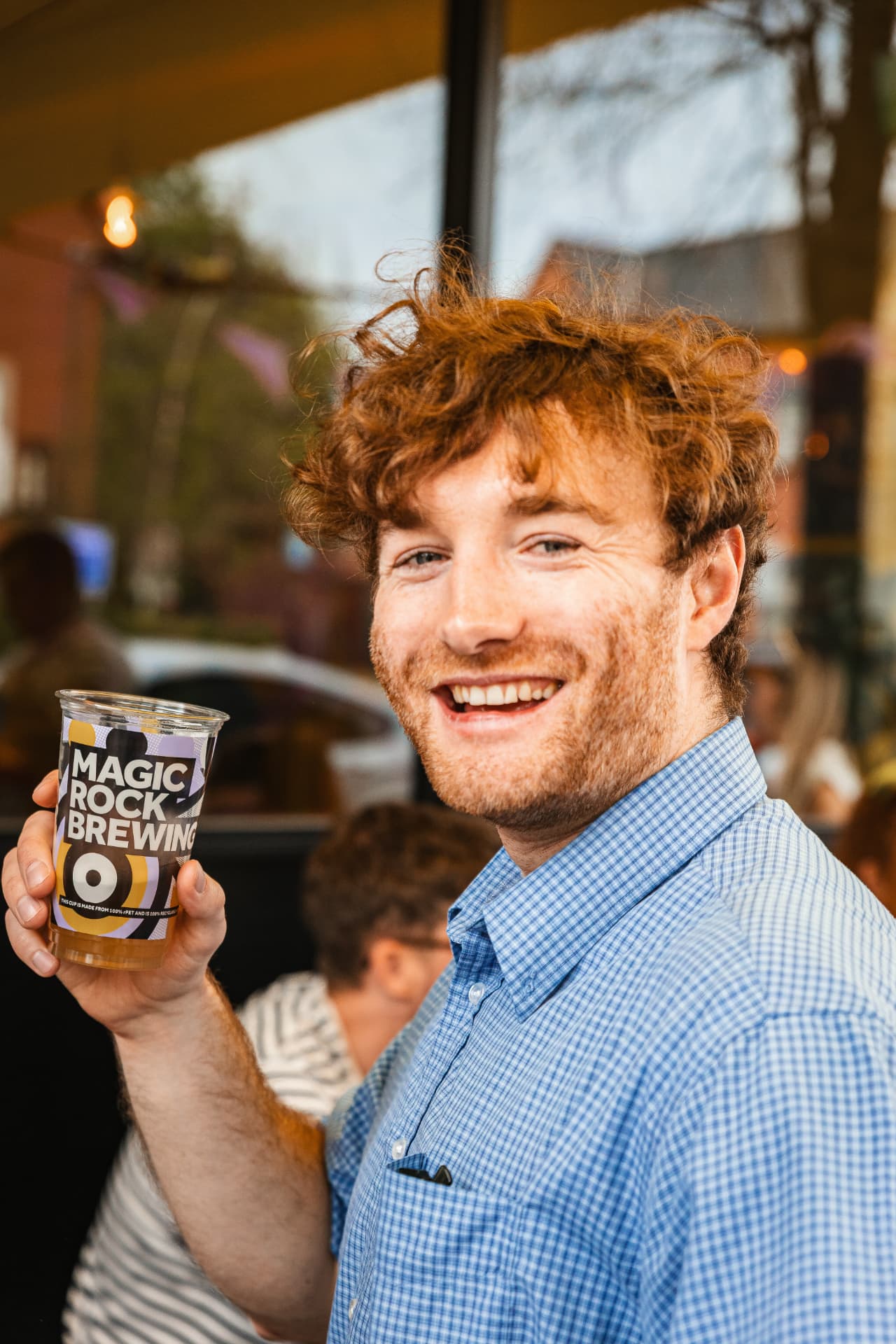 Customer smiling with a Magic Rock Brewing cup at a bar